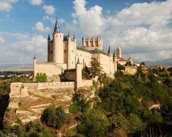 The Alcazar of Segovia is set against a backdrop of mountains